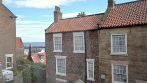 A row of brick houses with red-tiled roofs and white-framed windows. - 2 Bed in Whitby (oc-w075) (Whitby)