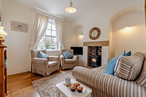 A cozy living room with striped furniture, a fireplace, and a television. - 2 Bed in Whitby (oc-w069) (Whitby)
