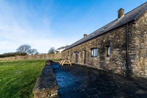 A stone building with a long, narrow patio area. - 3 Bed in Llanrhidian (oc-hh476) (Pen-clawdd)