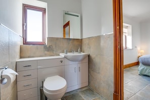 A modern bathroom with a toilet, sink, and vanity. - 3 Bed in Llanrhidian (oc-hh476) (Pen-clawdd)