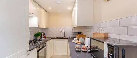 Mikrobølgeovn, ovn, oppvaskmaskin og høy barnestol