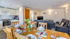 Um apartamento moderno com área de jantar, cozinha e sala de estar.