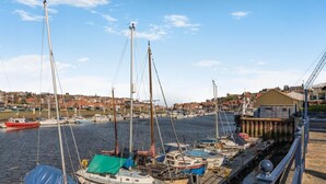 A harbor with boats docked, a pier, and a town in the background. - 2 Bed in Whitby (oc-w086) (Whitby)