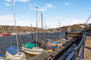 A harbor with boats docked, a pier, and a town in the background. - 2 Bed in Whitby (oc-w086) (Whitby)