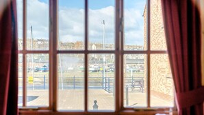 A window with a view of a dock area, a brick building, and a clear sky. - 2 Bed in Whitby (oc-w086) (Whitby)