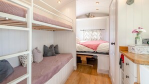 A compact room with bunk beds, a small desk, and a window with floral curtains. - 2 Bed in Barsham (oc-s32505) (Barsham)