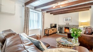 A living room with a fireplace, leather sofas, a TV, and a glass coffee table. - 2 Bed in Bodmin (oc-p00429) (Saint Teath)