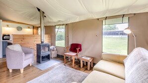 A tented accommodation with a wood-burning stove, seating area, and a small kitchenette. - 3 Bed in Barsham (oc-g32508) (Barsham)