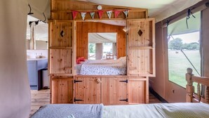 A tented room with a bed, wooden cabinets, and a view of the outdoors. - 3 Bed in Barsham (oc-g32508) (Barsham)