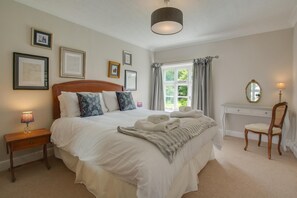 A neatly arranged bedroom with a large bed, bedside tables, a desk, and a chair. - 5 Bed in Sidestrand (oc-bize) (Trimingham)