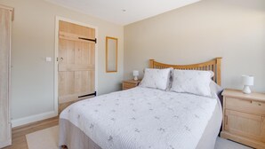 A bedroom with a wooden bed, two bedside tables, a nightstand, a wooden wardrobe, and a door. - 2 Bed in Weybread (oc-tclwey) (Upper Weybread)