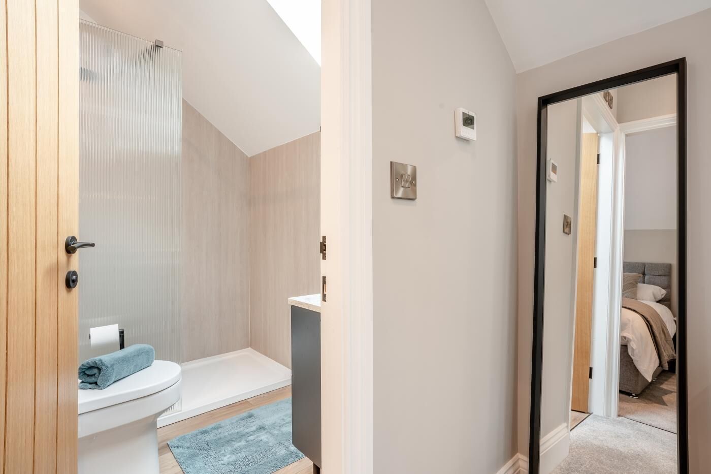 Uma casa de banho moderna com chuveiro, sanita e lavatório.