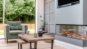 Een moderne woonkamer met een open haard, een comfortabele bank en een salontafel.