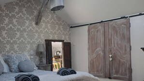 Een slaapkamer met een groot bed, dakraam, kledingkast en uitzicht op het interieur van de kamer.