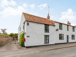 A white building with a tiled roof, a chimney, and a small garden area with a gate and mailbox. - 1 Bed in Middleton On The Wolds (oc-t32420) (Middleton-on-the-Wolds)