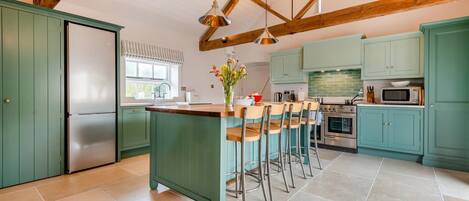 Een oven, een vaatwasser, een kinderstoel, kookgerei, borden en bestek