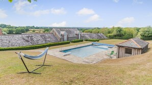 Ein Garten mit Swimmingpool, einer Hängematte und einem kleinen Geräteschuppen.