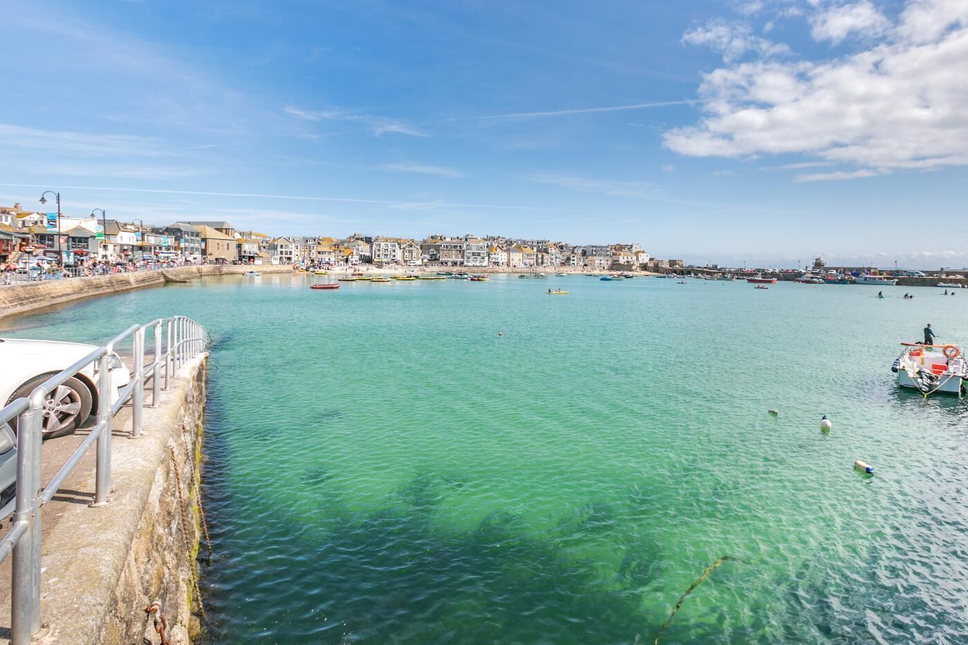 Une ville côtière dotée d’une promenade en bord de mer, de bateaux et de bâtiments qui bordent la côte.