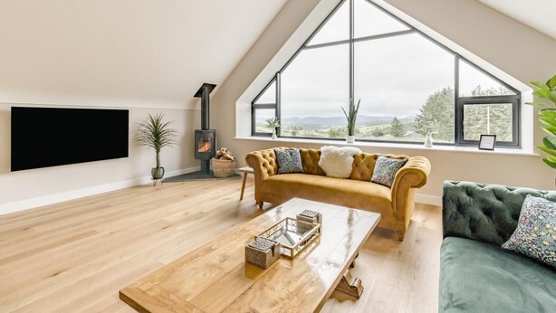 Un loft spacieux doté d’une grande verrière, d’une cheminée, d’un canapé et d’une table basse.