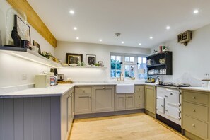 A kitchen with a large island, built-in appliances, and a window providing natural light. - 3 Bed in Walberswick (oc-spinn) (Walberswick)
