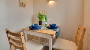 A dining table with blue plates and a potted plant, set against a plain wall with a light fixture. - 1 Bed in Bodham (oc-2141) (Bodham)