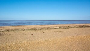Una spiaggia con cielo sereno e mare calmo.