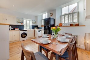 A modern kitchen with a dining area set for six. - 3 Bed in Newbridge (oc-p00869) (Newbridge)