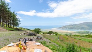 Ein Tisch im Freien mit Blick auf das Meer und die Hügel.