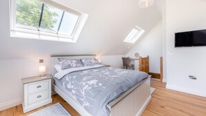 A bedroom with a bed, bedside tables, a desk, a chair, a TV, and a skylight. - 1 Bed in Umberleigh (oc-f32531) (Chittlehampton)