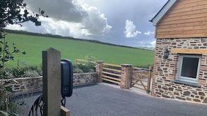 A rural property with a stone building, a wooden gate, and a paved driveway. - 1 Bed in Umberleigh (oc-f32531) (Chittlehampton)