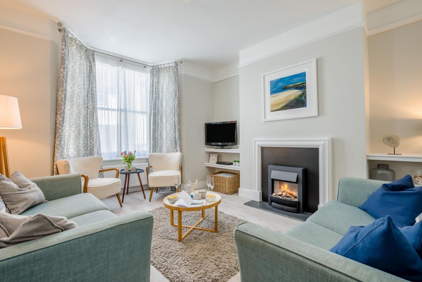 A living room with a fireplace, a television, and a sofa.