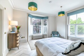 A bedroom with a bed, a dresser, a chair, and two pendant lights. - 3 Bed in Buxton (oc-p32528) (Buxton)