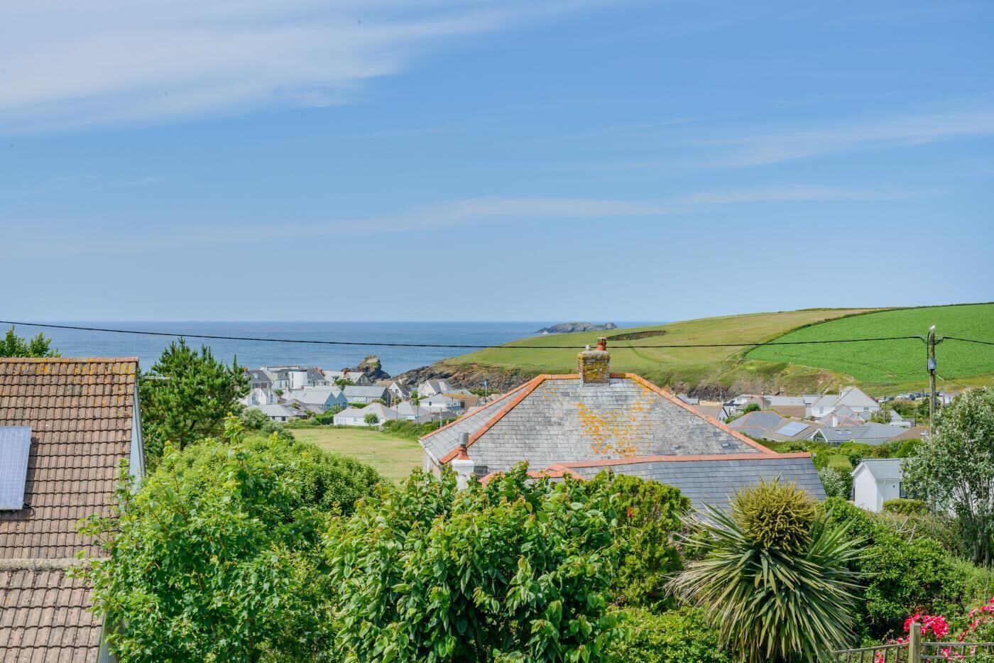 A coastal village with traditional stone houses, a clear sky, and a view of the sea.