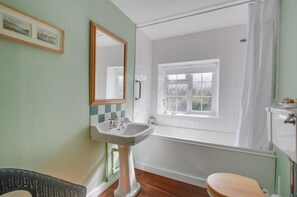 A bathroom with a sink, mirror, window, and bathtub. - 2 Bed in Letheringsett (oc-endco) (Letheringsett)