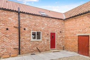 A brick building with a red door, a window, and a red door on the right. - 1 Bed in Marishes (oc-l32536) (Marishes)