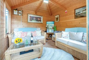 Ein gemütliches Cabin-Interieur mit einer Sofagarnitur, einem Glastisch und einem Korbtisch.