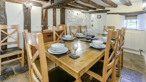 Ein Essbereich mit einem Holztisch, gedeckt für sechs Personen, umgeben von Holzstühlen.