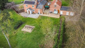 A large brick house with a spacious patio, a hot tub, and a small shed. - 4 Bed in Bronington (oc-g32599) (Bronington)