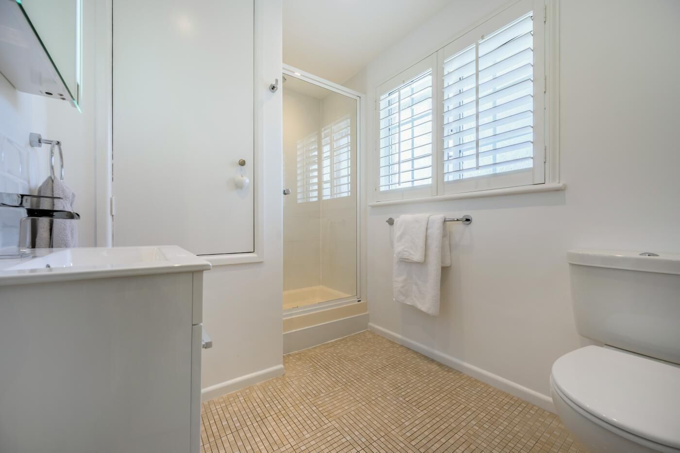 Une salle de bain avec douche, toilettes et lavabo.