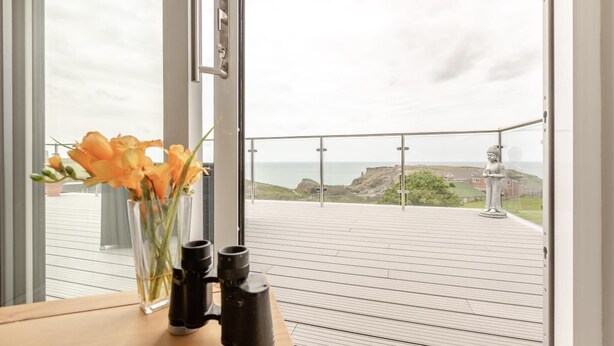 A balcony with a clear view of the sea and a statue. - 1 Bed in Tintagel (oc-pc084) (Tintagel)