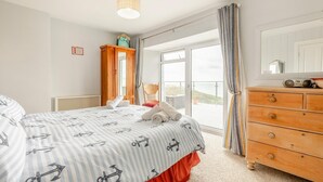 A bedroom with a bed, a dresser, a chair, and a view of the outdoors. - 1 Bed in Tintagel (oc-pc084) (Tintagel)