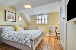 A bedroom with a bed, a nightstand, a chair, a radiator, and a window with blinds. - 2 Bed in Reydon (oc-42sea) (Reydon)