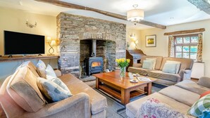 A cozy living room with a stone fireplace, comfortable seating, and a flat-screen TV. - 2 Bed in Cantref (oc-t32629) (Cantref)