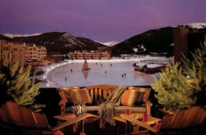 Une station de ski dotée d  ’une grande patinoire, de montagnes enneigées et d’un espace détente confortable avec vue sur la patinoire.