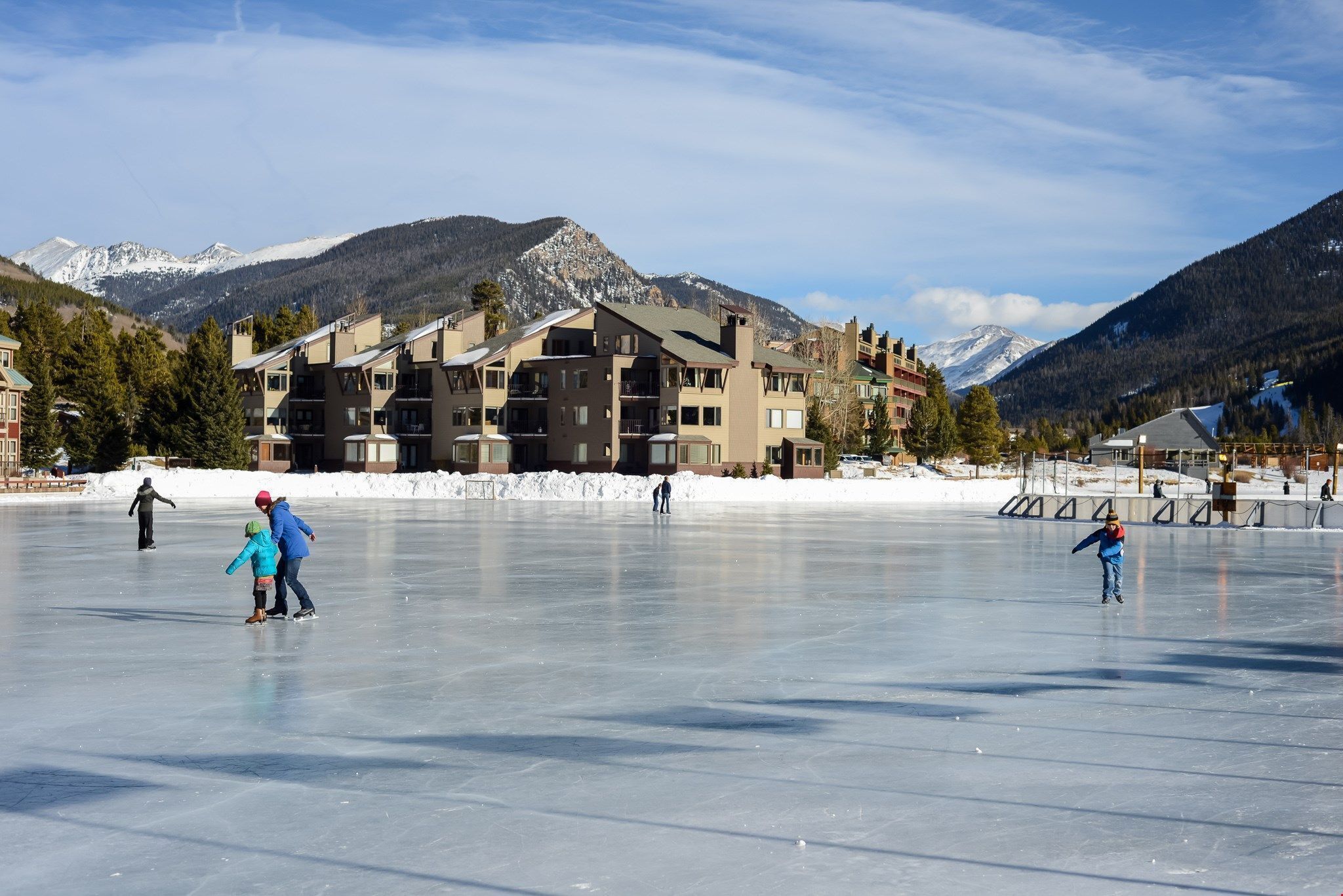 A large indoor ice skating rink with a mountainous backdrop.
