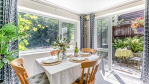 A dining area with a table set for four, surrounded by wooden chairs with cushions. - 2 Bed in Lynton (oc-p13830) (Barbrook)