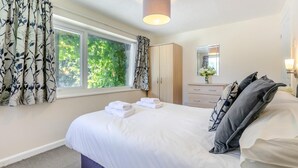 A bedroom with a large bed, a wardrobe, a dresser, and a window with curtains. - 2 Bed in Lynton (oc-p13830) (Barbrook)