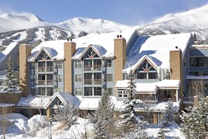 A multi-story hotel with a ski slope in the background. - Studio with Mountain Decor and Great Balcony Views (Breckenridge)