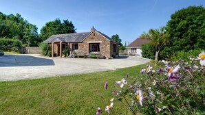 A stone building with a paved driveway and a grassy lawn. - 1 Bed in Wadebridge (oc-p00440) (Saint Issey)