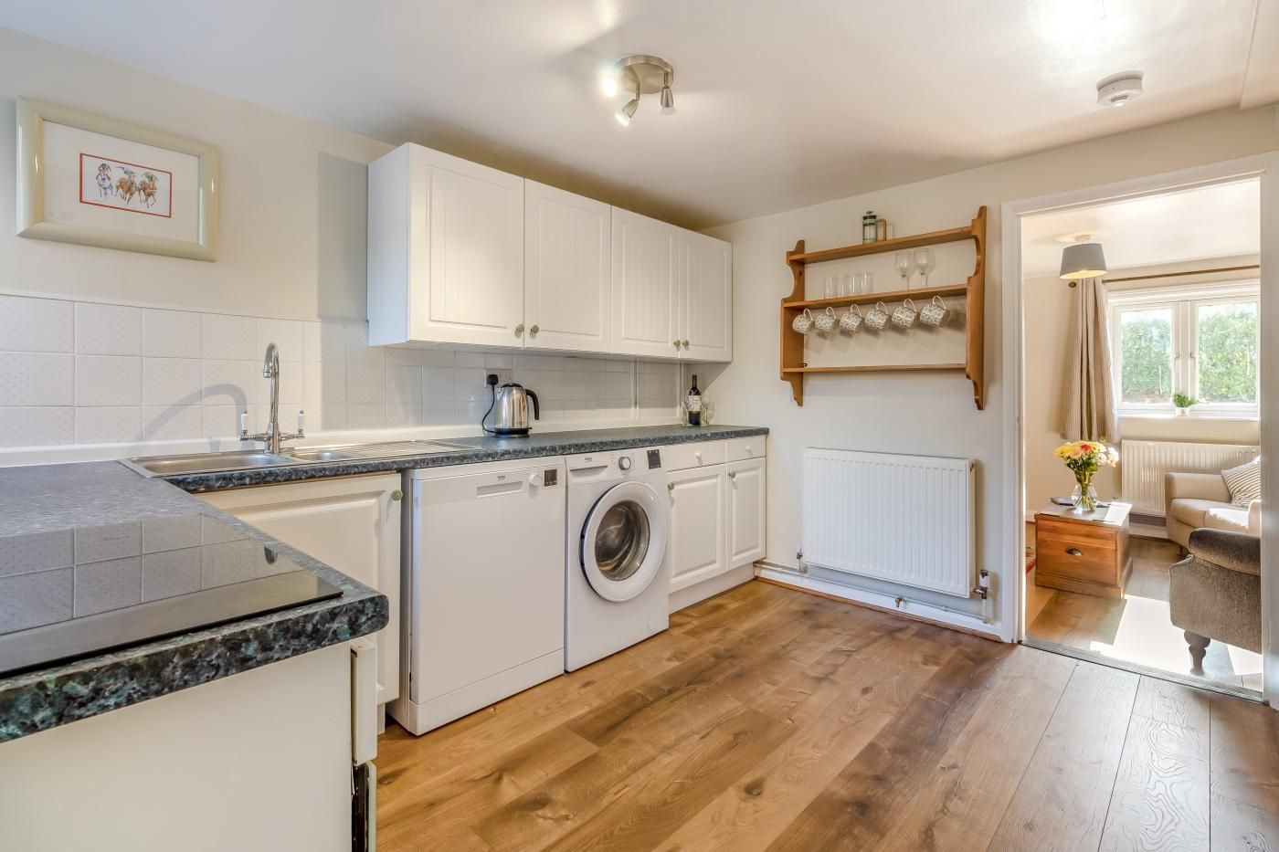 Una cocina compacta con lavadora, un lavabo y una encimera.